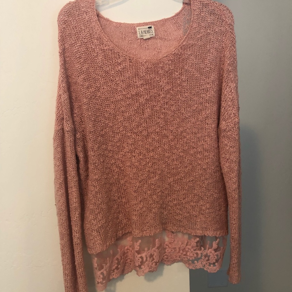 Pink sweater with lace trim.